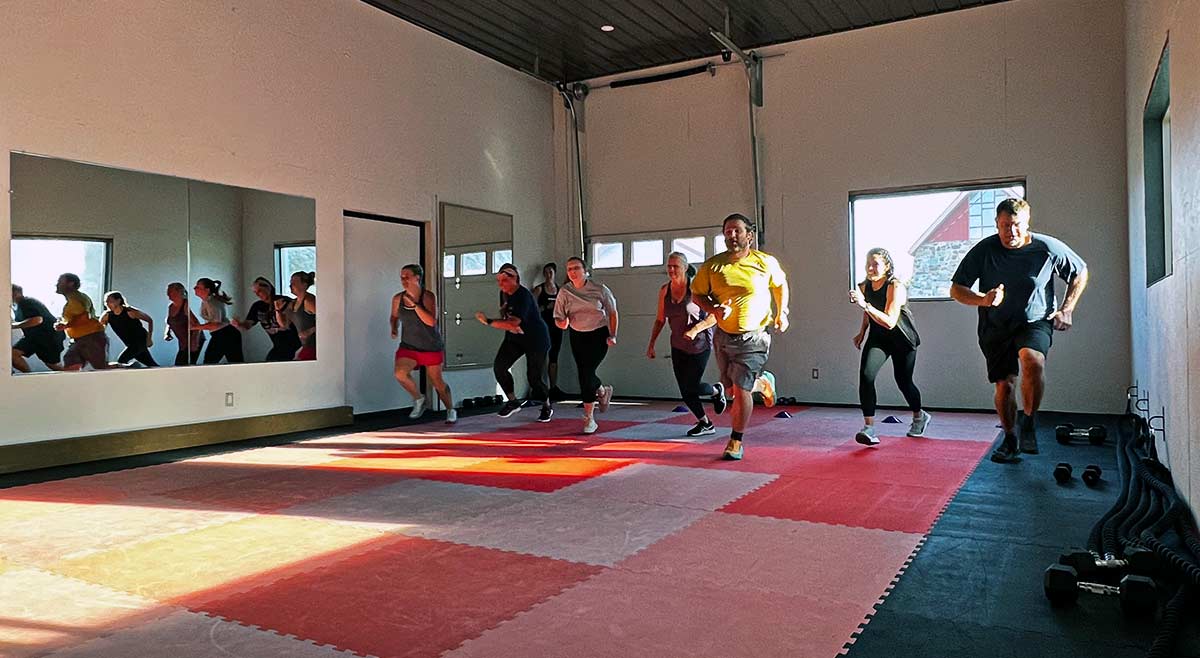 men and women running in room as a warm up